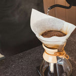 Hypnos decaf coffee brewing in a pour-over with a paper filter and hot water stream